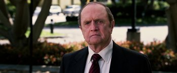 Movie still from “Horrible Bosses” (2011), directed by Seth Gordon – An older man wearing a suit and tie; Close Up shot, Over the shoulder angle