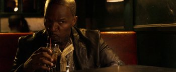 Movie still from “Horrible Bosses” (2011), directed by Seth Gordon – A man sitting at a table with a drink in his hand; Close Up shot, High angle