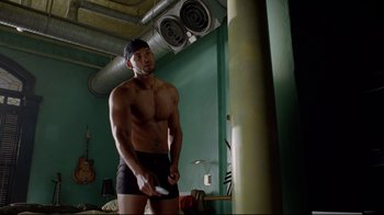 Movie still from “I, Robot” (2004), directed by Alex Proyas – A man holding a wii controller in a room; Medium shot, Over the shoulder angle