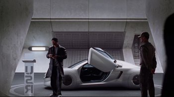 Movie still from “I, Robot” (2004), directed by Alex Proyas – A man standing in front of a white car; Wide shot, High angle