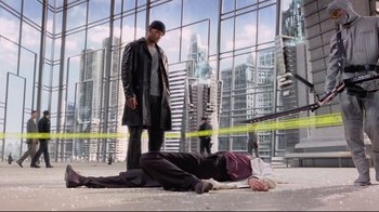 Movie still from “I, Robot” (2004), directed by Alex Proyas – A man standing next to another man laying on the ground; Wide shot, High angle