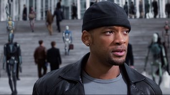 Movie still from “I, Robot” (2004), directed by Alex Proyas – A person wearing a jacket and hat; Close Up shot, Over the shoulder angle