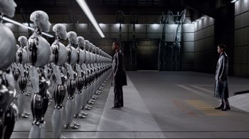 Movie still from “I, Robot” (2004), directed by Alex Proyas – A man standing in front of a row of robots; Wide shot, High angle
