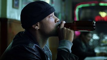 Movie still from “I, Robot” (2004), directed by Alex Proyas – A young man drinking a beer from a bottle; Close Up shot, Low angle