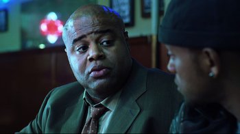 Movie still from “I, Robot” (2004), directed by Alex Proyas – A man in a suit and tie talking to another man in a suit and tie; Close Up shot, Over the shoulder angle