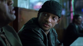 Movie still from “I, Robot” (2004), directed by Alex Proyas – A person wearing a leather jacket and a hat; Close Up shot, Over the shoulder angle