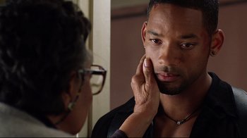 Movie still from “I, Robot” (2004), directed by Alex Proyas – A man looking in the reflection of himself in a mirror; Close Up shot, Over the shoulder angle