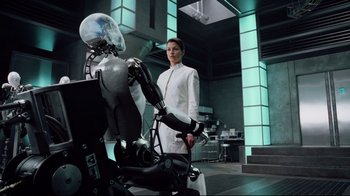 Movie still from “I, Robot” (2004), directed by Alex Proyas – A woman standing next to a robot in a room; Medium shot, Low angle