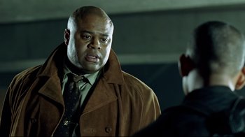 Movie still from “I, Robot” (2004), directed by Alex Proyas – A man in a brown coat and a tie; Close Up shot, Over the shoulder angle