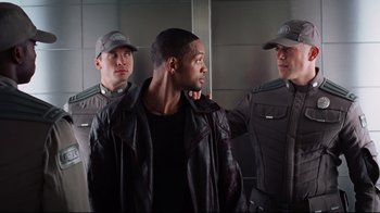 Movie still from “I, Robot” (2004), directed by Alex Proyas – A group of men standing next to each other in a room; Medium shot, Over the shoulder angle