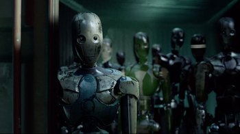 Movie still from “I, Robot” (2004), directed by Alex Proyas – A group of mannequins are lined up against a wall; Medium shot, Low angle