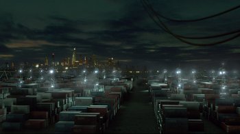 Movie still from “I, Robot” (2004), directed by Alex Proyas – A large warehouse filled with boxes at night time; Extreme Wide shot, High angle