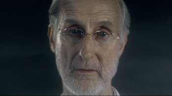 Movie still from “I, Robot” (2004), directed by Alex Proyas – An older man with glasses is looking at the camera; Close Up shot, Over the shoulder angle