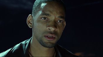 Movie still from “I, Robot” (2004), directed by Alex Proyas – A person wearing a black jacket; Close Up shot, Over the shoulder angle
