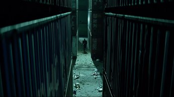 Movie still from “I, Robot” (2004), directed by Alex Proyas – A person is walking down a dark alleyway; Extreme Wide shot, High angle