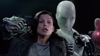Movie still from “I, Robot” (2004), directed by Alex Proyas – A woman in a leather jacket holding a wrench next to a robot; Close Up shot, Over the shoulder angle