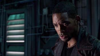 Movie still from “I, Robot” (2004), directed by Alex Proyas – A man in a black shirt and a brown leather jacket; Close Up shot, Over the shoulder angle