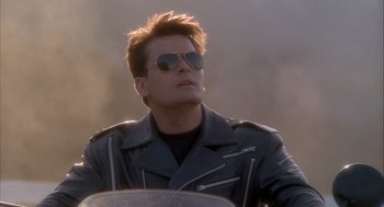 Movie still from “Hot Shots!” (1991), directed by Jim Abrahams – A man wearing sunglasses and a leather jacket; Close Up shot, Low angle