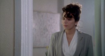 Movie still from “Hot Shots!” (1991), directed by Jim Abrahams – A woman in a gray jacket and a white shirt; Close Up shot, Over the shoulder angle