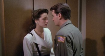 Movie still from “Hot Shots!” (1991), directed by Jim Abrahams – A man and a woman standing next to each other; Medium shot, Over the shoulder angle