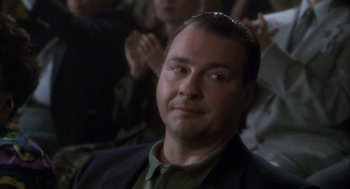 Movie still from “Hot Shots!” (1991), directed by Jim Abrahams – A person wearing a suit and tie; Close Up shot, Over the shoulder angle