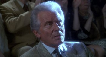 Movie still from “Hot Shots!” (1991), directed by Jim Abrahams – An older man in a suit and tie looking to his left; Close Up shot, Low angle