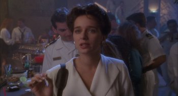 Movie still from “Hot Shots!” (1991), directed by Jim Abrahams – A woman in a white jacket is holding a microphone; Close Up shot, Over the shoulder angle