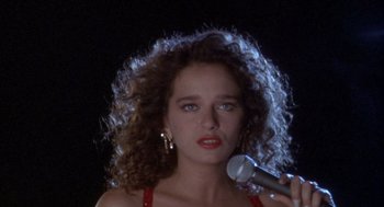 Movie still from “Hot Shots!” (1991), directed by Jim Abrahams – A person holding a microphone; Close Up shot, High angle