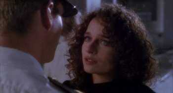 Movie still from “Hot Shots!” (1991), directed by Jim Abrahams – A woman with curly brown hair looking at a man; Close Up shot, Over the shoulder angle