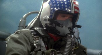 Movie still from “Hot Shots!” (1991), directed by Jim Abrahams – A man in a fighter pilot's helmet with american flag on it; Close Up shot, Low angle