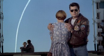 Movie still from “Hot Shots!” (1991), directed by Jim Abrahams – A man and a woman standing next to each other; Medium shot, Low angle