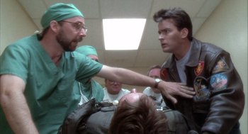 Movie still from “Hot Shots!” (1991), directed by Jim Abrahams – Two men in green scrubs are fighting in a room; Medium shot, Low angle