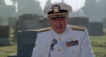 Movie still from “Hot Shots!” (1991), directed by Jim Abrahams – A person wearing a uniform and a hat; Medium shot, Low angle