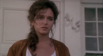Movie still from “Hot Shots!” (1991), directed by Jim Abrahams – A person with long curly hair; Close Up shot, Over the shoulder angle