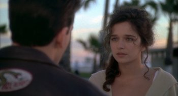 Movie still from “Hot Shots!” (1991), directed by Jim Abrahams – A young woman looking at a young man in front of palm trees; Close Up shot, Over the shoulder angle