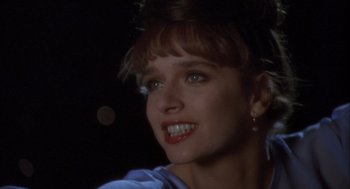 Movie still from “Hot Shots!” (1991), directed by Jim Abrahams – A woman's face in a dark room; Close Up shot, Over the shoulder angle