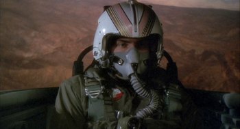 Movie still from “Hot Shots!” (1991), directed by Jim Abrahams – A man in a fighter pilot's helmet in the cockpit of an aircraft; Close Up shot, Low angle