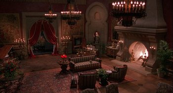 Movie still from “Hot Shots! Part Deux” (1993), directed by Jim Abrahams – A living room filled with lots of furniture and a fire place; Extreme Wide shot, High angle