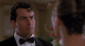 Movie still from “Hot Shots! Part Deux” (1993), directed by Jim Abrahams – A man in a suit and bow tie looking at a woman; Close Up shot, Over the shoulder angle