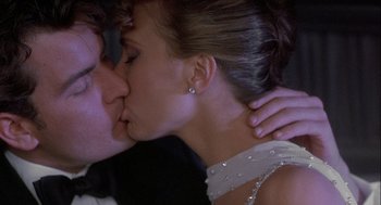 Movie still from “Hot Shots! Part Deux” (1993), directed by Jim Abrahams – A person kissing another person on the cheek; Close Up shot, Over the shoulder angle