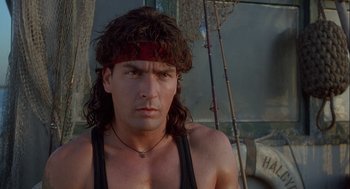 Movie still from “Hot Shots! Part Deux” (1993), directed by Jim Abrahams – A person with long hair wearing a headband; Close Up shot, Low angle