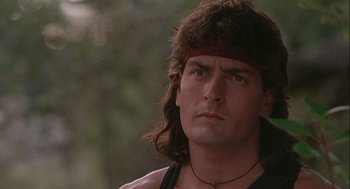 Movie still from “Hot Shots! Part Deux” (1993), directed by Jim Abrahams – A person with long hair wearing a headband; Close Up shot, Low angle
