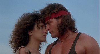 Movie still from “Hot Shots! Part Deux” (1993), directed by Jim Abrahams – A man and a woman face to face in front of a sky background; Close Up shot, Low angle