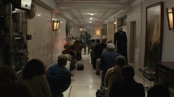 Movie still from “Hotel Artemis” (2018), directed by Drew Pearce – A group of people are walking down a hallway; Wide shot, High angle
