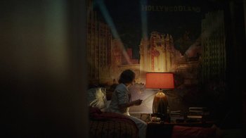 Movie still from “Hotel Artemis” (2018), directed by Drew Pearce – A woman is reading a book in a bedroom; Wide shot, Low angle
