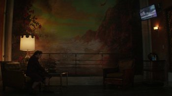 Movie still from “Hotel Artemis” (2018), directed by Drew Pearce – A woman sitting on a chair in front of a painting; Extreme Wide shot, High angle