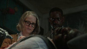 Movie still from “Hotel Artemis” (2018), directed by Drew Pearce – A woman and a man looking at something on a table; Medium shot, Over the shoulder angle