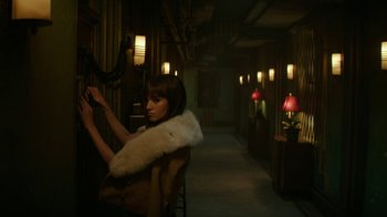 Movie still from “Hotel Artemis” (2018), directed by Drew Pearce – A woman sitting in a chair in a dark room; Medium shot, High angle