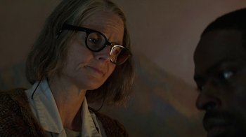 Movie still from “Hotel Artemis” (2018), directed by Drew Pearce – An older woman wearing glasses and a white shirt; Close Up shot, Low angle