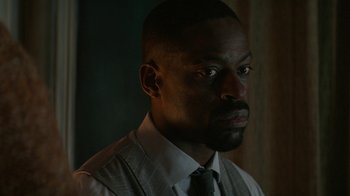 Movie still from “Hotel Artemis” (2018), directed by Drew Pearce – A man in a suit and tie looking to his left; Close Up shot, Over the shoulder angle